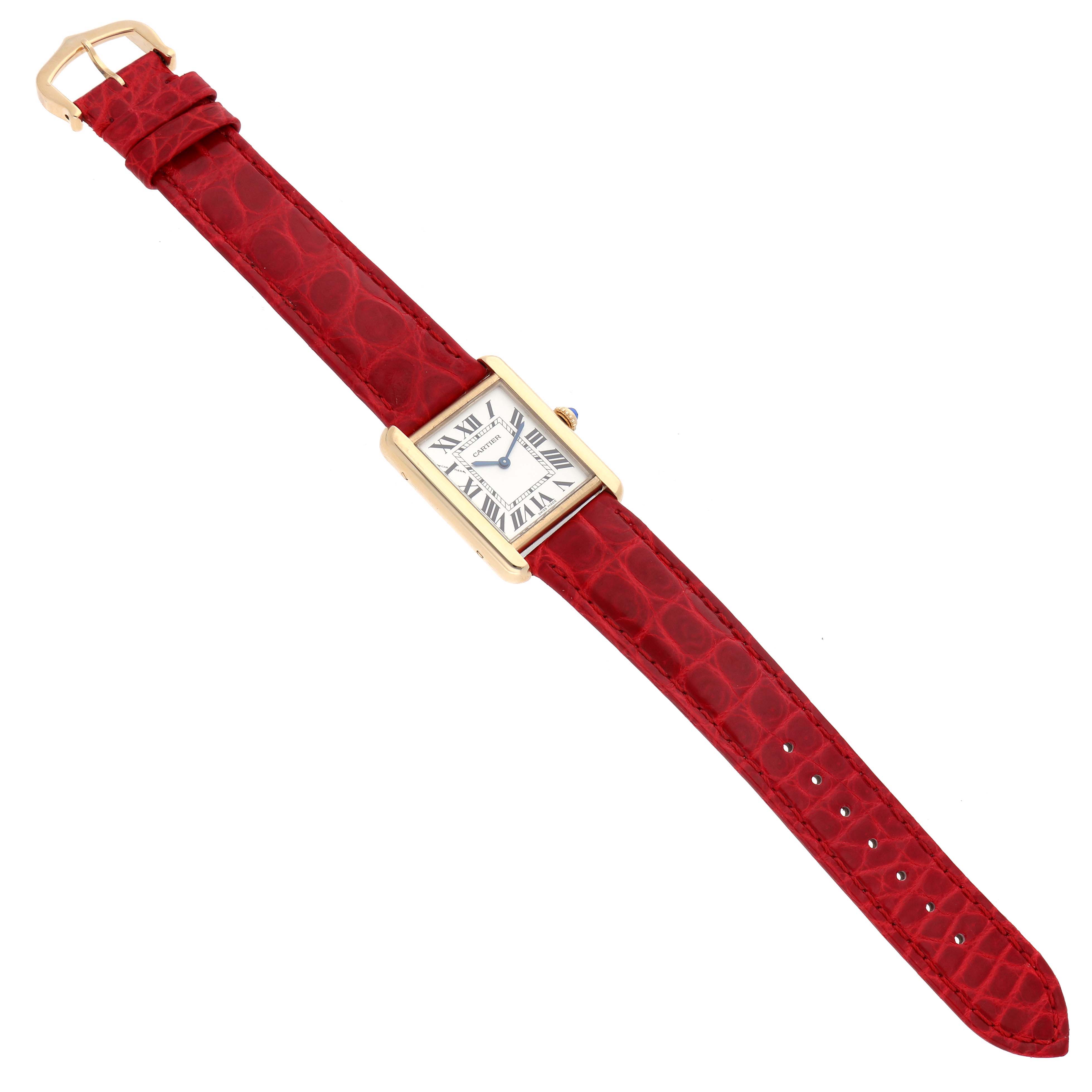 The Cartier Tank Solo W5200002 Women's Yellow Gold Silver Dial watch is shown from a top-down angle, highlighting its rectangular face and red leather strap.