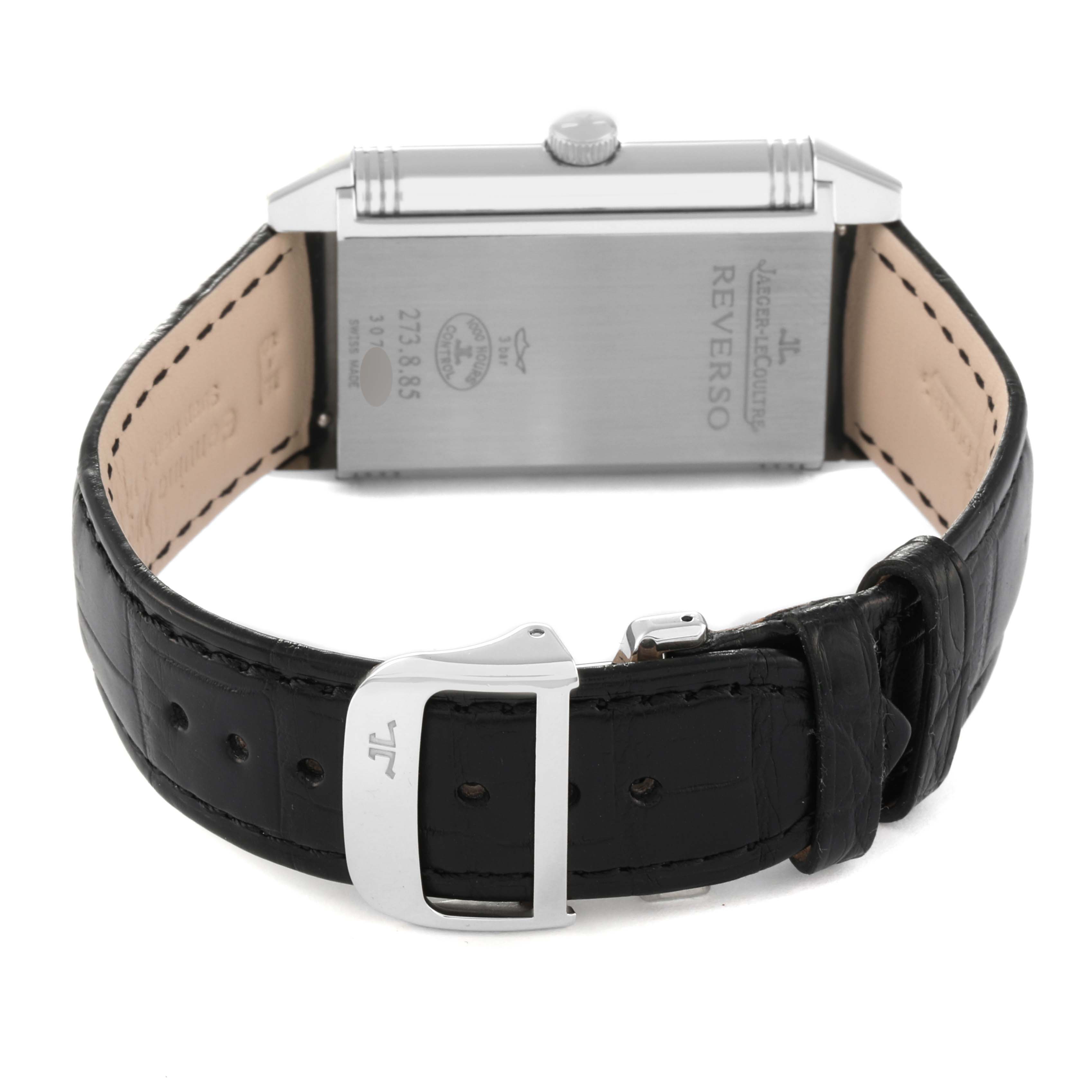 The image shows the back view of a Jaeger-LeCoultre Reverso watch, highlighting the case back, strap, and buckle.