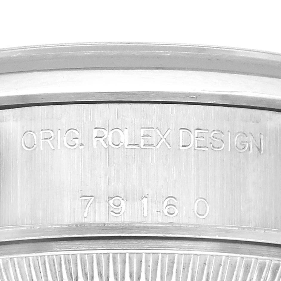 The image shows an up-close view of the case edge on a Rolex Date 79160 Women's Stainless Steel Black Dial 79160 Women's Stainless Steel Black Dial model, displaying its engraving details.