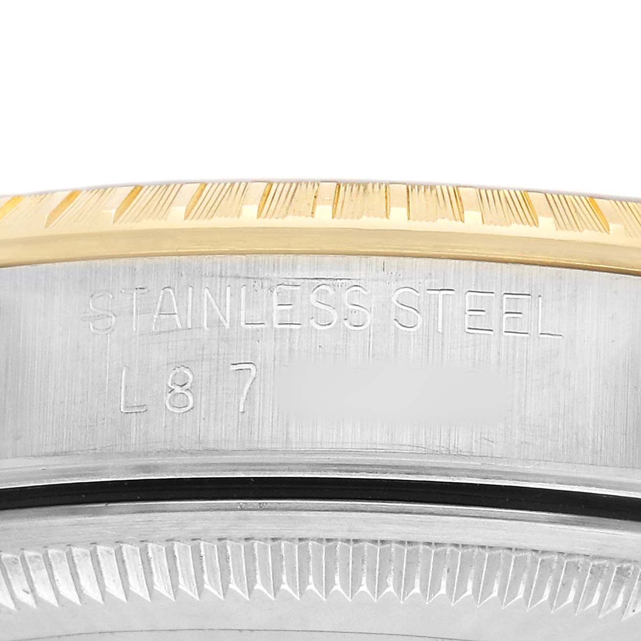The image shows a close-up of the Rolex Date 15223 Men's Steel and Gold (two tone) Champagne Dial model's case side, highlighting engraving and the fluted bezel.