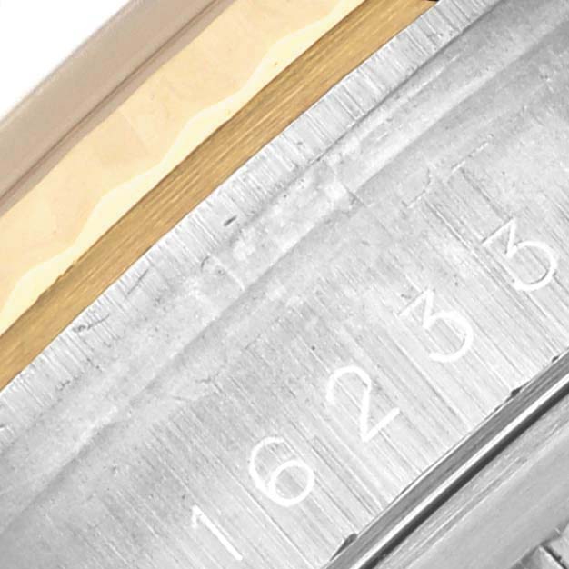 The image shows a close-up of the case side and rehaut of a Rolex Datejust 16233 Men's Steel and Gold (two tone) Grey Dial 16233 Men's Steel and Gold (two tone) Grey Dial, displaying engraved text.