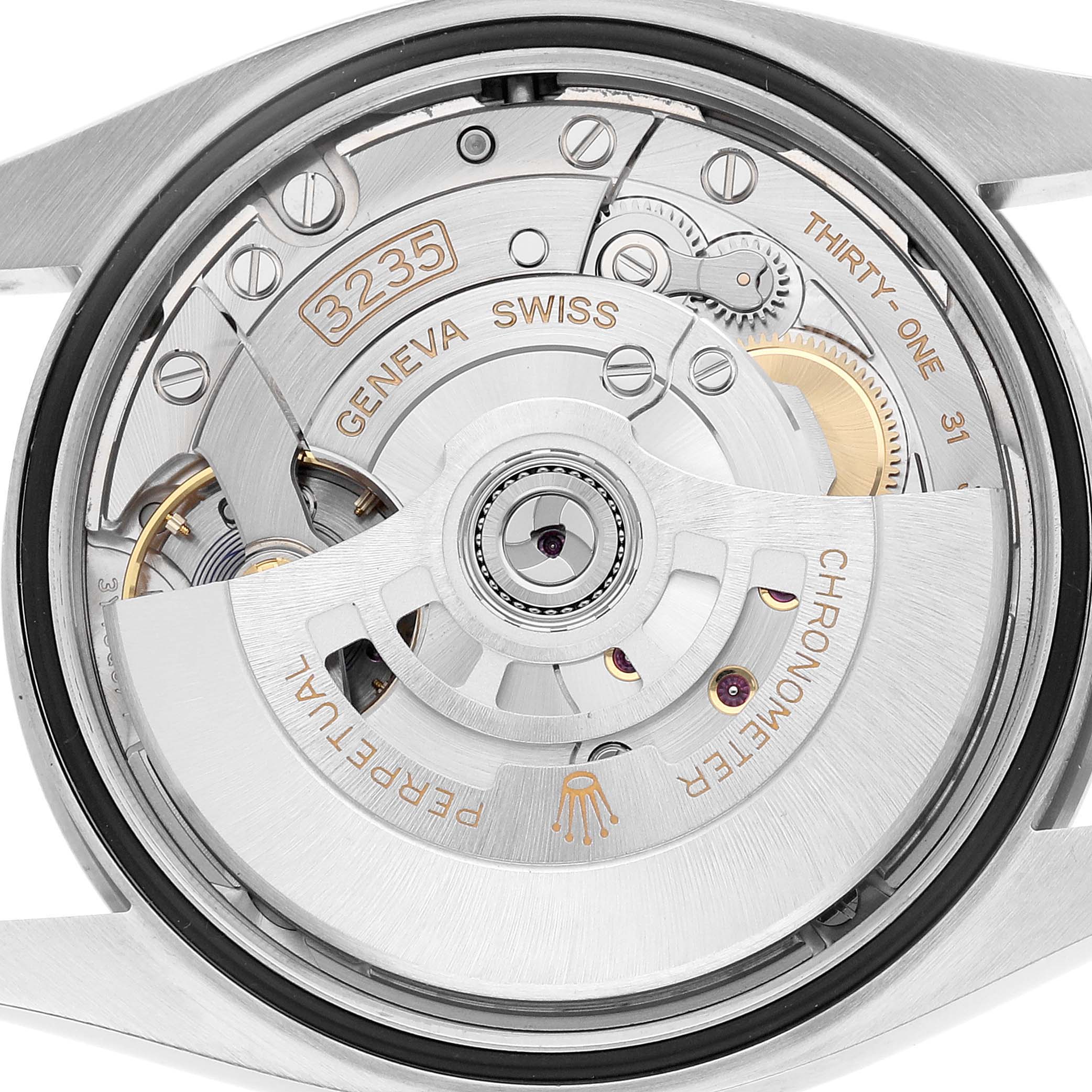 The image shows the movement of a Rolex Datejust 126200 Men's Stainless Steel White Dial watch, focusing on the intricate internal mechanics and gears from the back view.