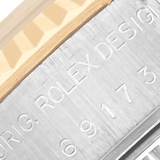 The image shows a close-up of the side of a Rolex Datejust 69173 Women's Steel and Gold (two tone) Blue Dial 69173 Women's Steel and Gold (two tone) Blue Dial case, featuring engraved text and part of the bezel.