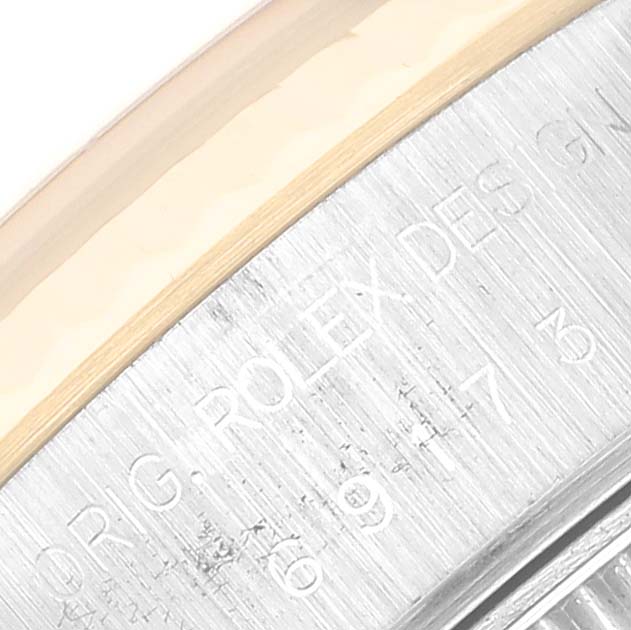 This close-up image shows the side of a Rolex Datejust 69173 Women's Steel and Gold (two tone) Champagne Dial 69173 Women's Steel and Gold (two tone) Champagne Dial watch with the "ROLEX DESIGN" engraving.