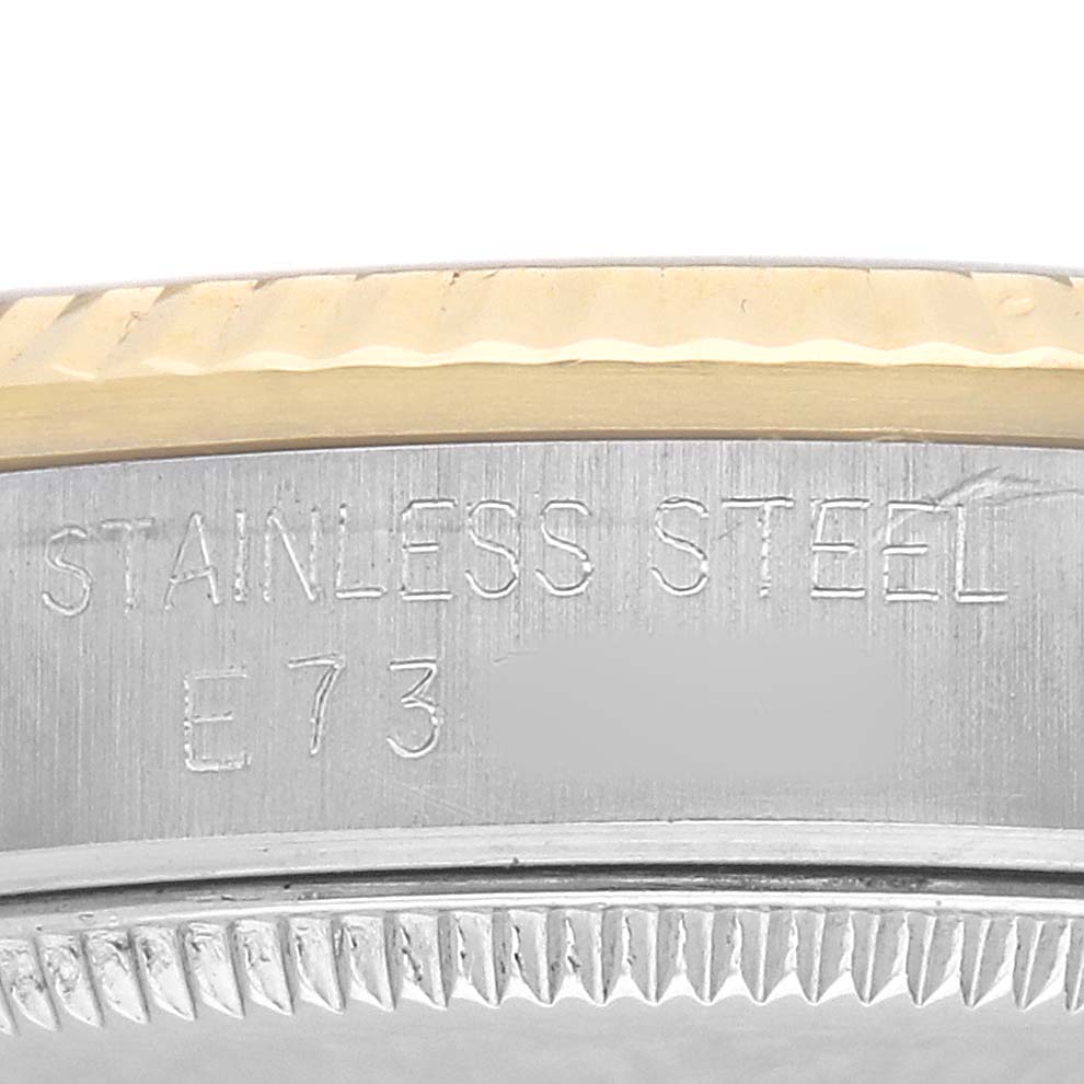The image shows the side of the stainless steel casing and bezel of a Rolex Datejust 68273 Women's Steel and Gold (two tone) Champagne Dial watch with engraved text.