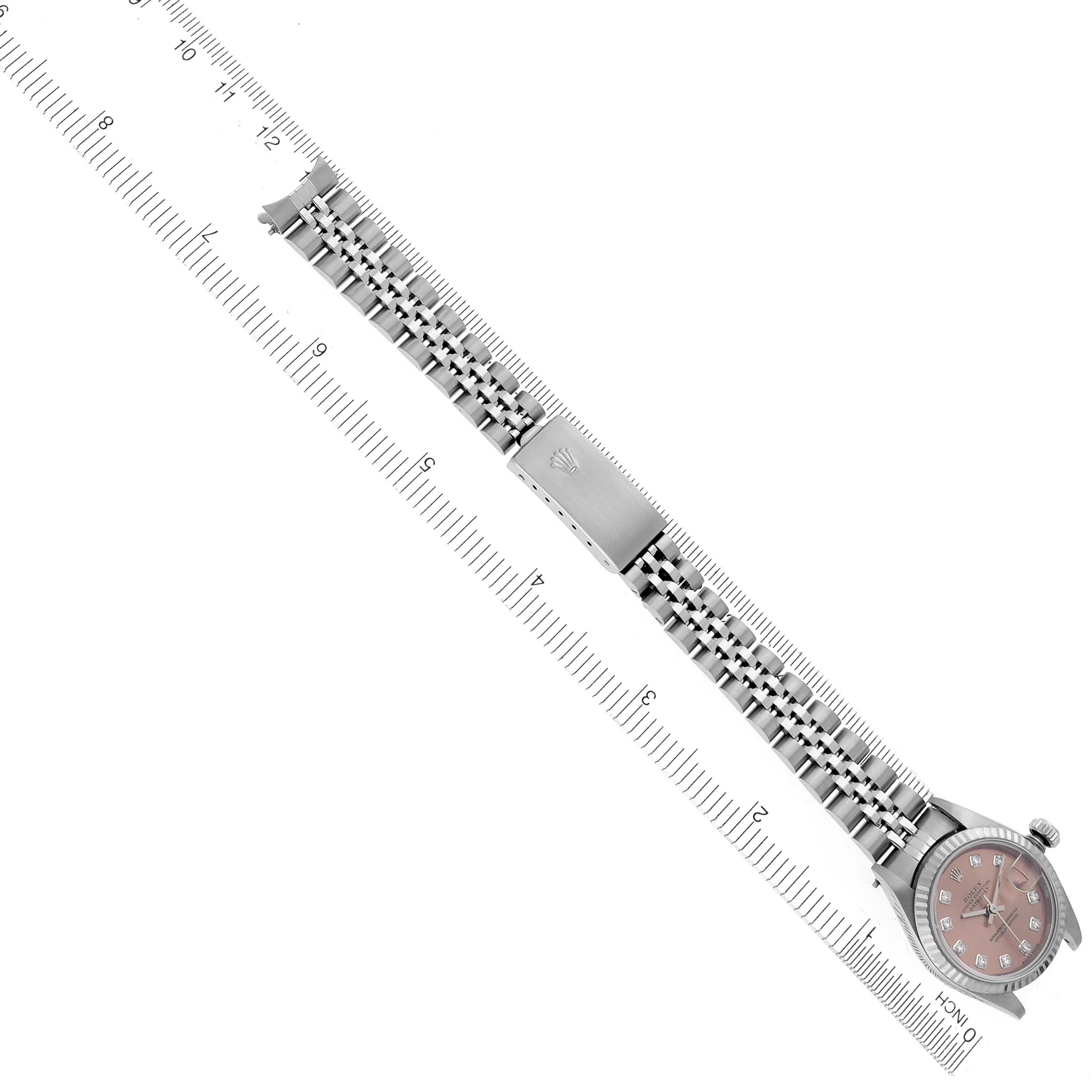 The Rolex Datejust 79174 Women's Stainless Steel Pink Dial 79174 Women's Stainless Steel Pink Dial watch is displayed from an overhead angle, showcasing the bracelet, clasp, and face against a ruler.
