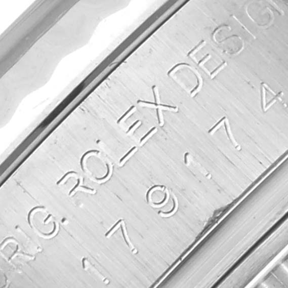 The image shows the engraved side of the Rolex Datejust 179174 Women's Stainless Steel Silver Dial 179174 Women's Stainless Steel Silver Dial case, highlighting its serial numbers and designer text.