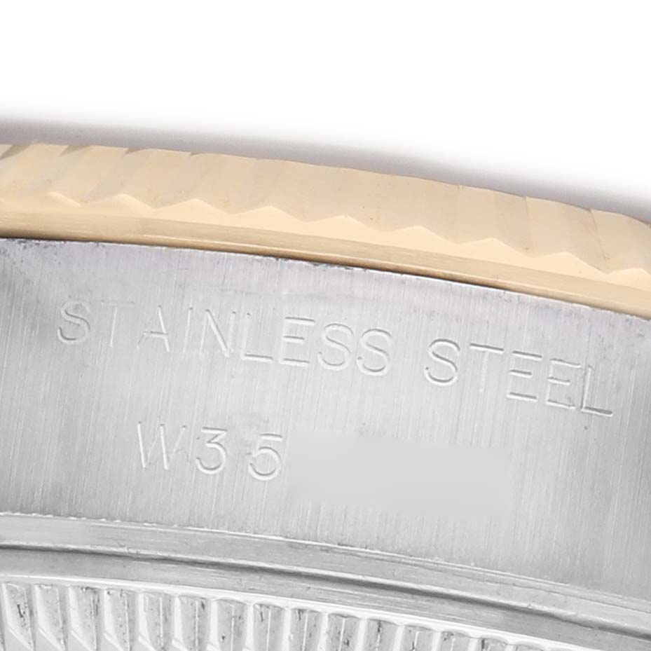 The image shows a close-up of the side of a Rolex Datejust 69173 Women's Steel and Gold (two tone) Champagne Dial watch, highlighting the stainless steel engraving.