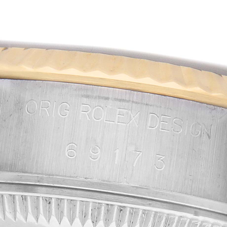 The image shows a close-up angle of the side of a Rolex Datejust 69173 Women's Steel and Gold (two tone) Champagne Dial watch, highlighting the engraved model details on the case.