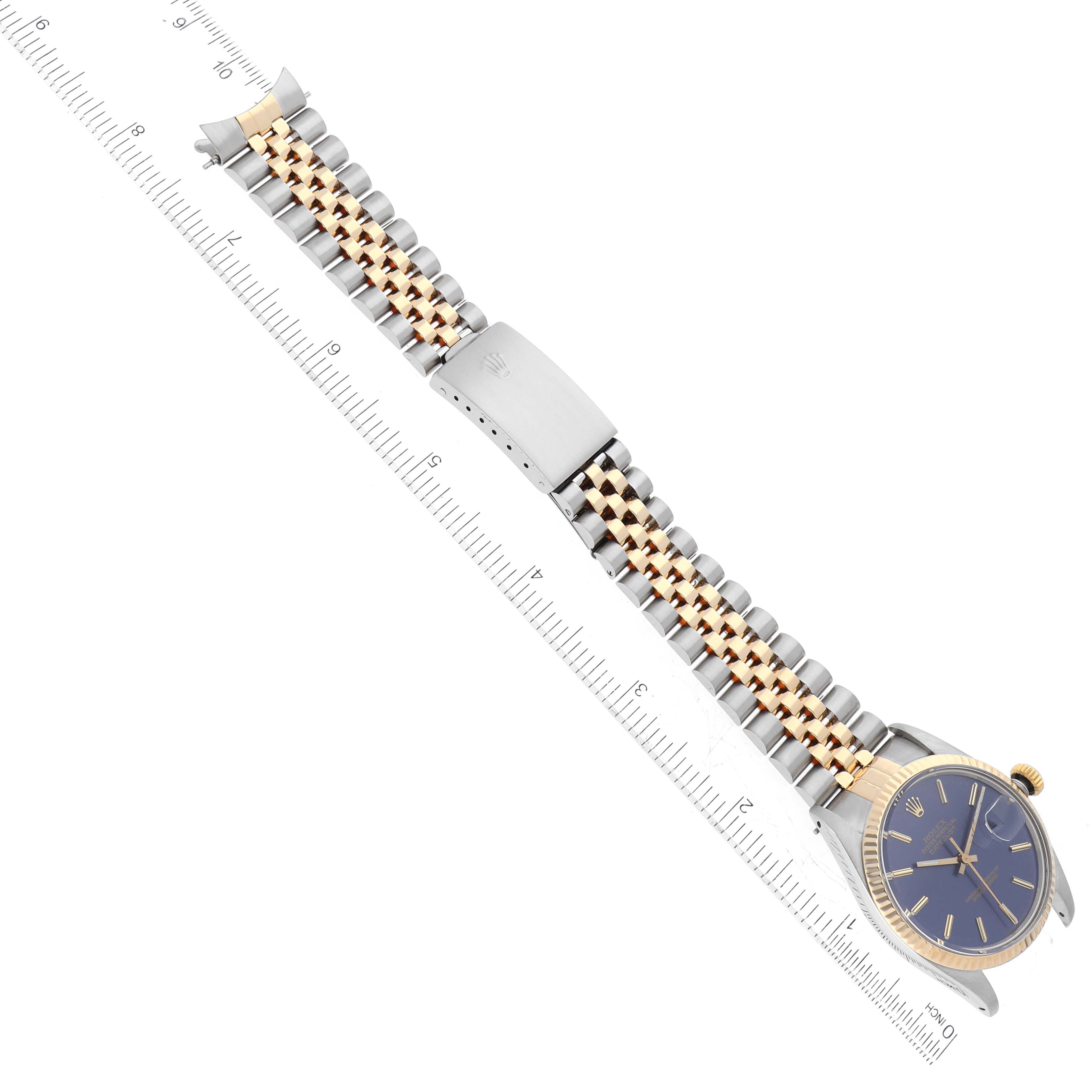 The Rolex Vintage Collection 16013 Men's Steel and Gold (two tone) Blue Dial 16013 Men's Steel and Gold (two tone) Blue Dial watch is shown diagonally with a focus on the dial, bracelet, and clasp next to a ruler.