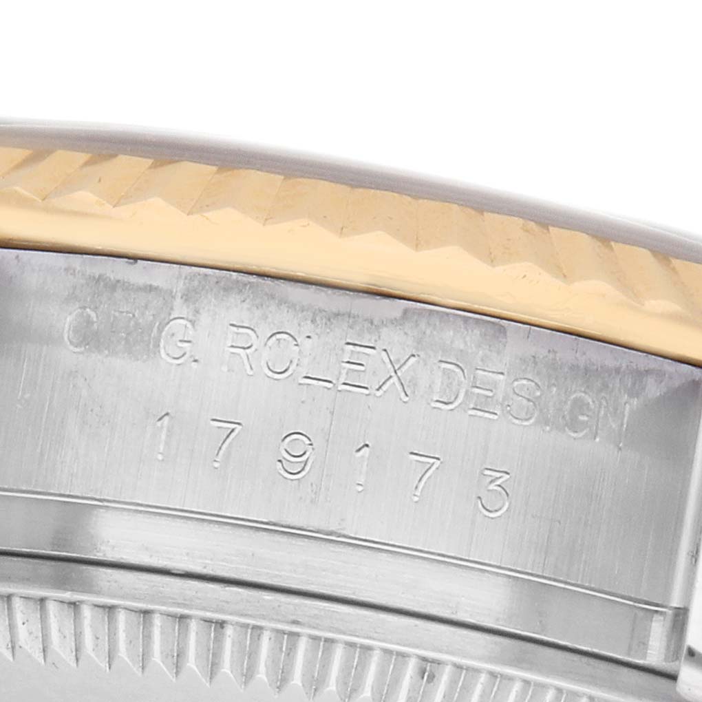 The image shows a close-up of the case side of a Rolex Datejust 179173 Women's Steel and Gold (two tone) Champagne Dial, featuring the model number engraving and the fluted bezel.