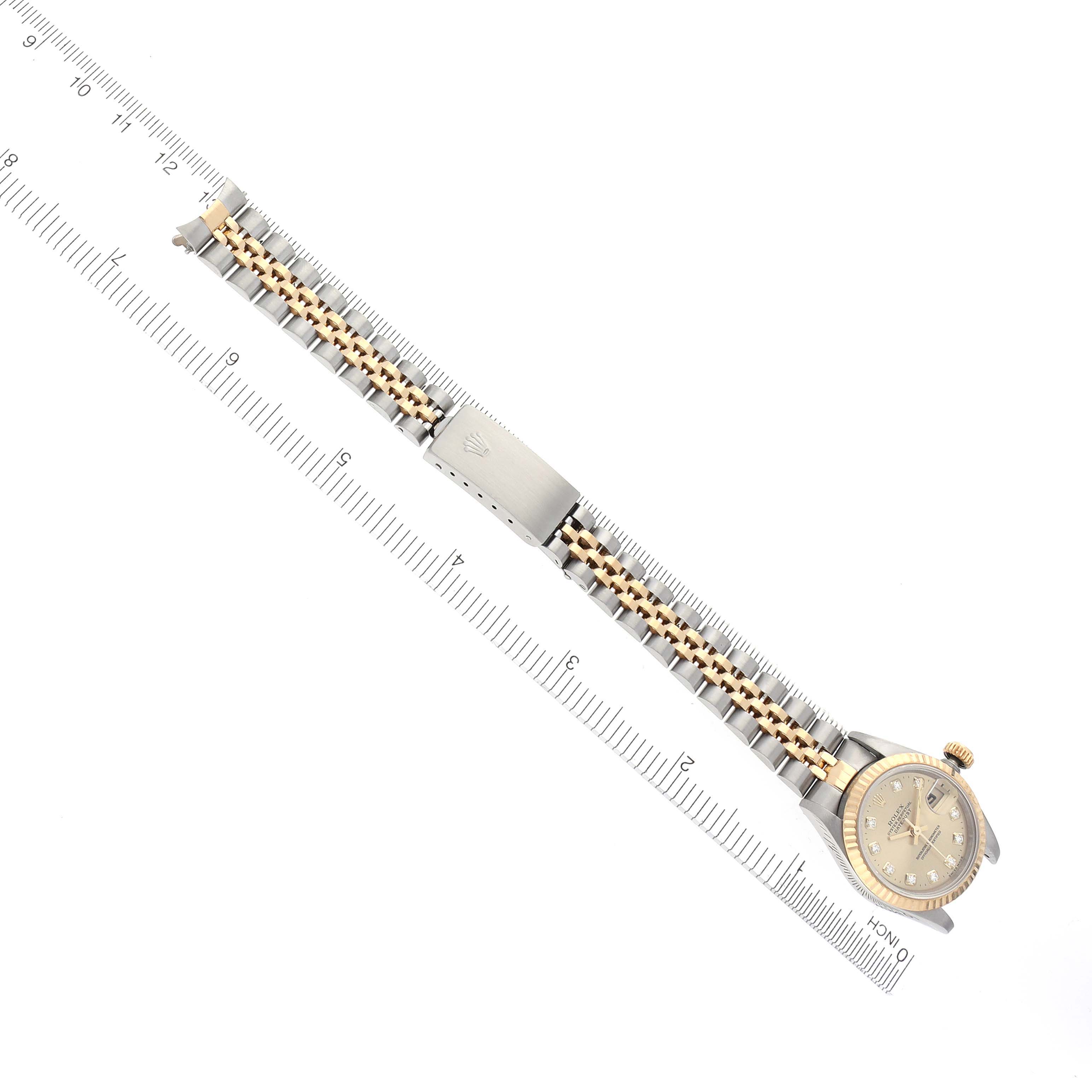 The Rolex Datejust 69173 Women's Steel and Gold (two tone) Champagne Dial 69173 Women's Steel and Gold (two tone) Champagne Dial watch is shown from a top-down angle, displaying the full bracelet and face alongside a measuring ruler.