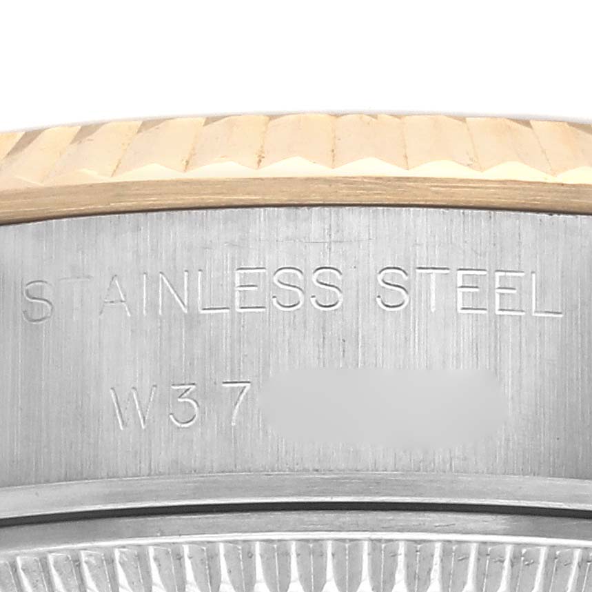 The image shows a close-up of the case edge and fluted bezel of a Rolex Datejust 69173 Women's Steel and Gold (two tone) Champagne Dial 69173 Women's Steel and Gold (two tone) Champagne Dial with "STAINLESS STEEL" engraved.