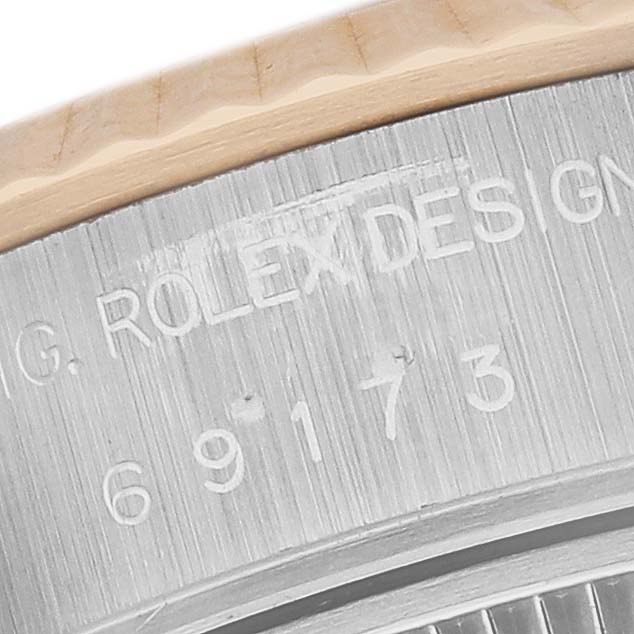 This image shows the side angle of a Rolex Datejust 69173 Women's Steel and Gold (two tone) White Dial 69173 Women's Steel and Gold (two tone) White Dial, focusing on the engraved case with "ROLEX DESIGN" visible.