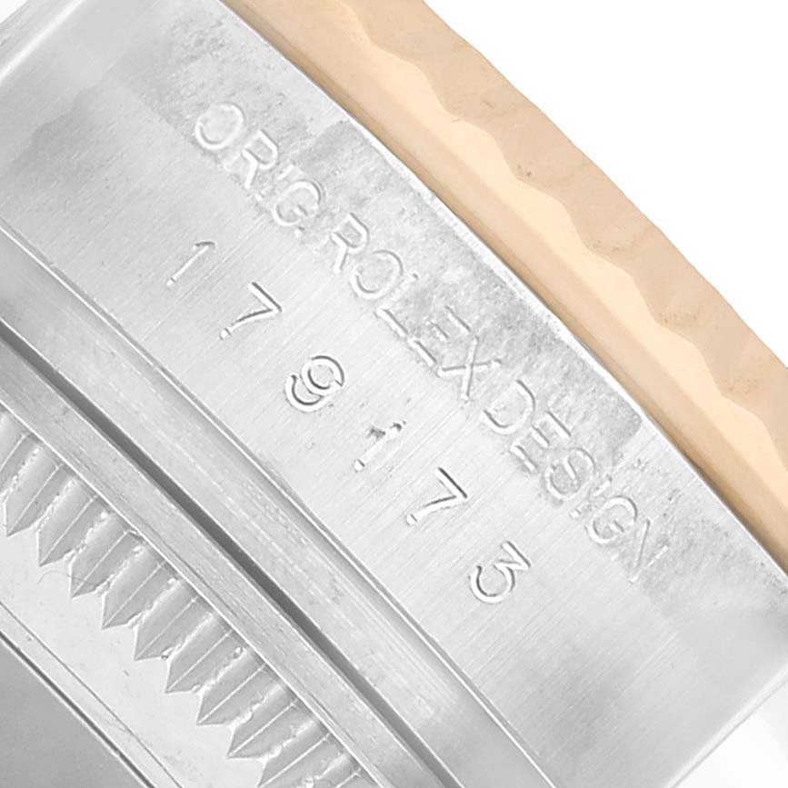 The image shows a close-up of the side of a Rolex Datejust 179173 Women's Steel and Gold (two tone) White Dial, highlighting the engraved model and design details.