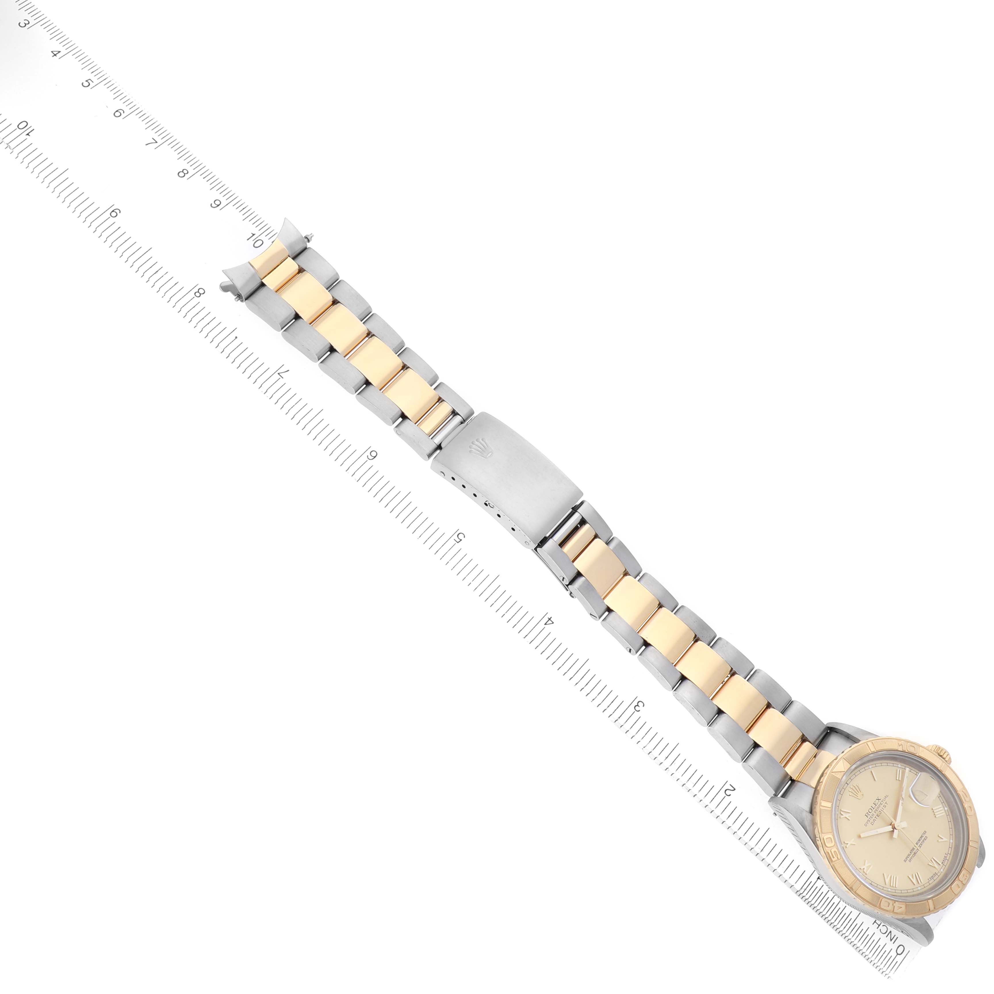 The Rolex Turn-o-Graph 16263 Men's Steel and Gold (two tone) Champagne Dial watch is shown laid flat, highlighting its two-tone bracelet and clasp, with a ruler for scale.