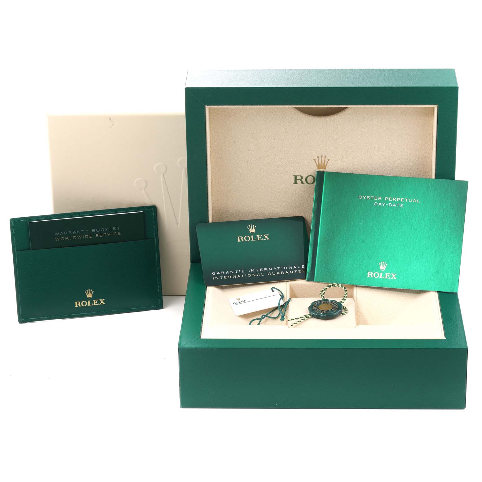 The image shows accessories for the Rolex President 228348RBR Men's Yellow Gold Champagne Dial 228348RBR Men's Yellow Gold Champagne Dial model, including the box, warranty booklet, tags, and instruction manual.