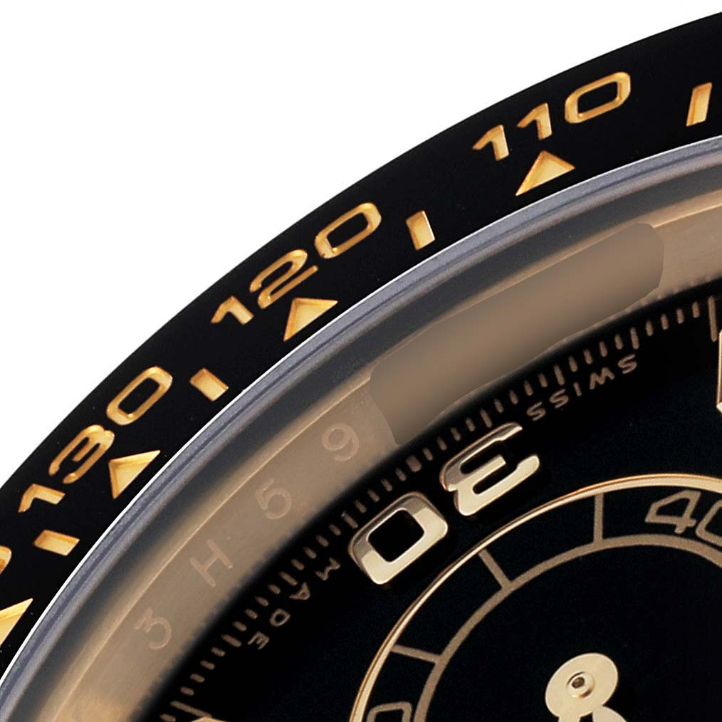 This close-up angle shows the bezel and part of the dial of a Rolex Daytona 116518 Men's Yellow Gold Black Dial 116518 Men's Yellow Gold Black Dial watch, highlighting the tachymeter scale and numeral markers.