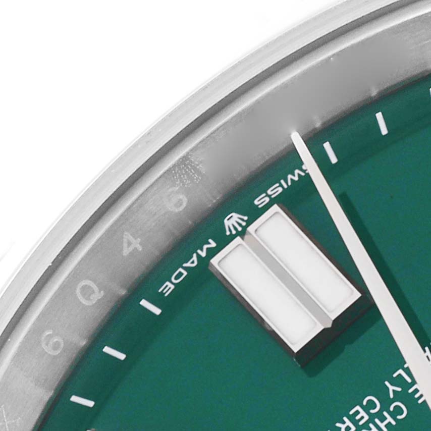 The image shows a close-up of the dial and hands of a Rolex Oyster Perpetual 124300 Men
s Stainless Steel Green Dial 124300 Men
s Stainless Steel Green Dial watch, focusing on the "SWISS MADE" text and part of the hour markers.