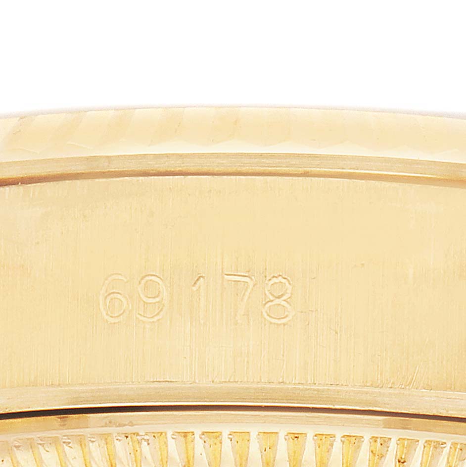 This image shows a close-up of the Rolex President 69178 Women's Yellow Gold Champagne Dial model's case side with engraved numbers.