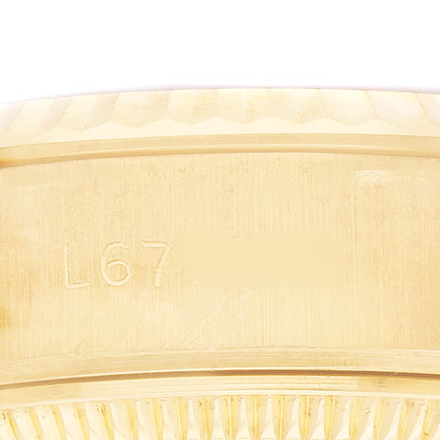 The image shows a close-up of the side of a Rolex President 69178 Women's Yellow Gold Champagne Dial model, featuring part of the case with engravings.