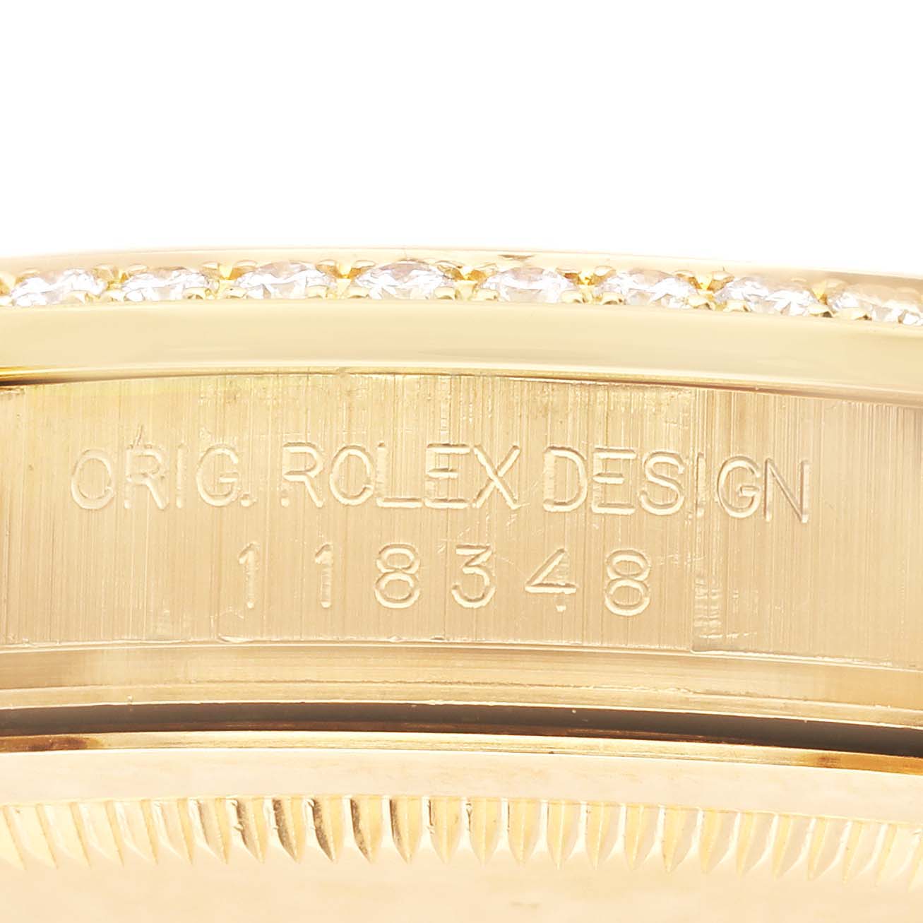 The Rolex President 118348 Men's Yellow Gold Silver Dial 118348 Men's Yellow Gold Silver Dial watch is shown in a close-up of its side, featuring the model number and "ORIG. ROLEX DESIGN" engraving.