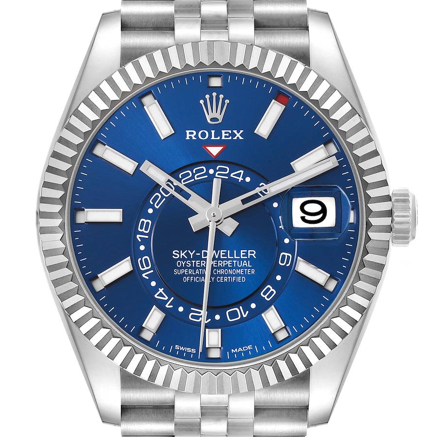 The Rolex Sky-Dweller is shown from a front angle, displaying the bezel, blue dial, hour markers, hands, date window, and bracelet.