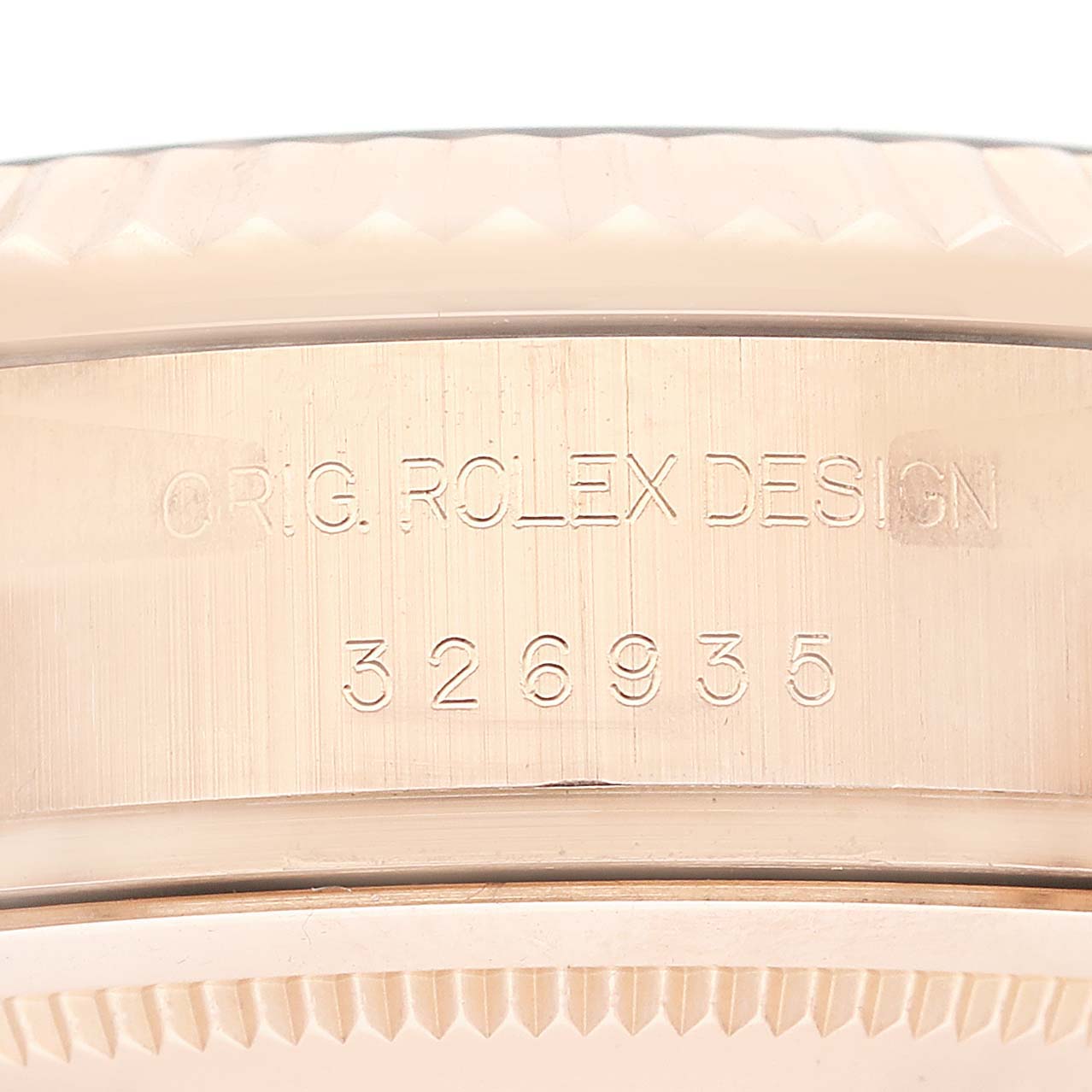 This close-up image shows the engraved serial number and "ROLEX DESIGN" text on the case side of a Rolex Sky-Dweller 326935 Men's Rose Gold Pink Dial 326935 Men's Rose Gold Pink Dial watch.