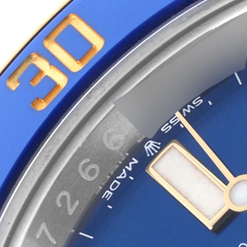 The image shows a close-up of the Rolex Submariner 126613 Men's Steel and Gold (two tone) Blue Dial 126613 Men's Steel and Gold (two tone) Blue Dial's blue bezel with a gold "30" and part of the dial with hands and text.