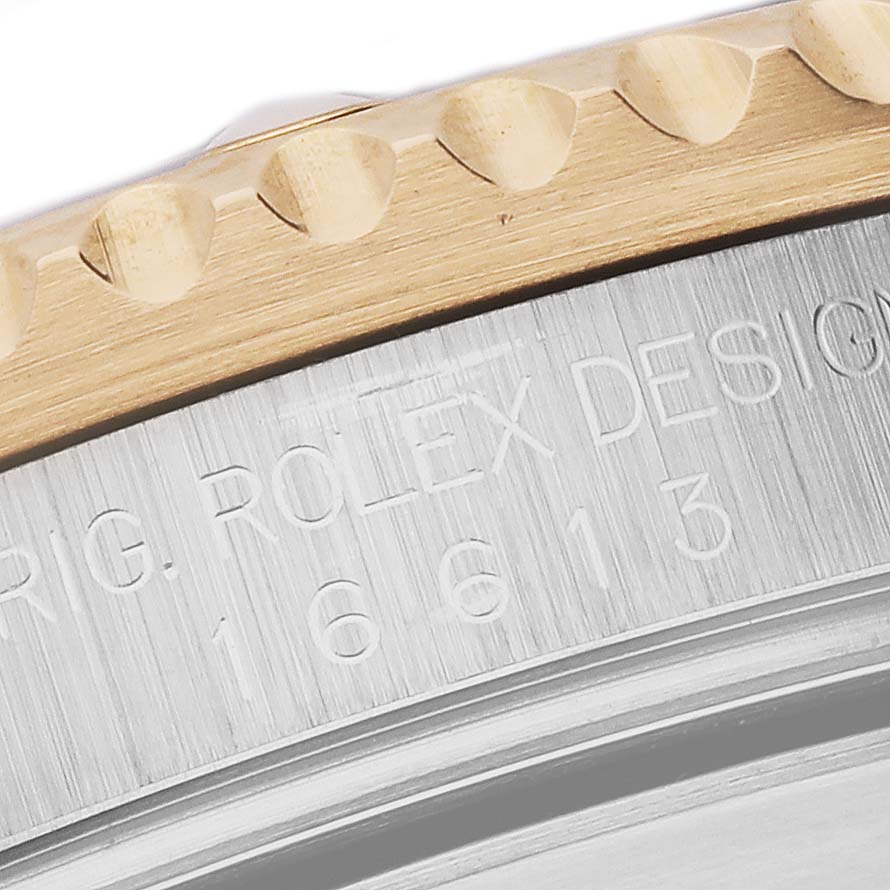 The image shows a close-up of the side view of the bezel and engraved case of a Rolex Submariner 16613 Men's Steel and Gold (two tone) Blue Dial 16613 Men's Steel and Gold (two tone) Blue Dial.