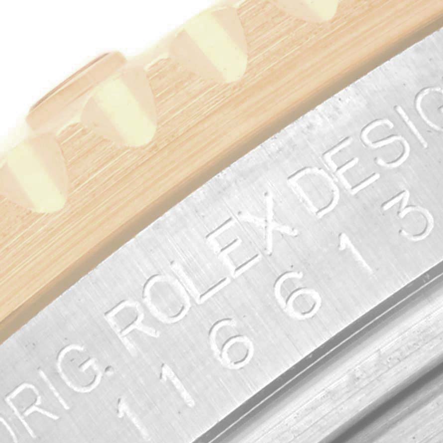 The image shows a close-up of the side of a Rolex Submariner 116613LN Men
s Steel and Gold (two tone) Blue Dial 116613LN Men
s Steel and Gold (two tone) Blue Dial, focusing on the bezel edge and case engraving.