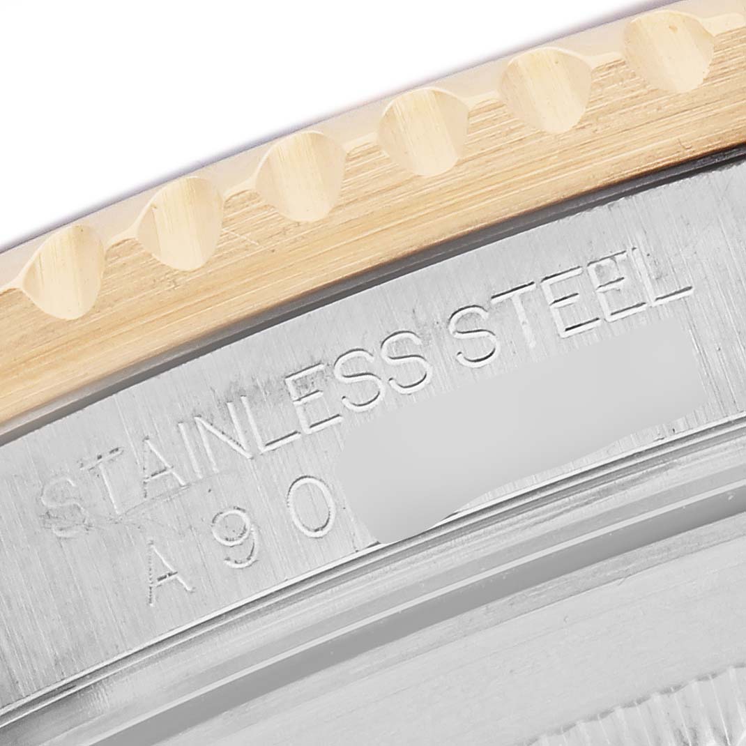 The image shows a close-up of the case back edge and bezel of a Rolex Submariner 16613 Men's Steel and Gold (two tone) Silver Dial, highlighting the "Stainless Steel" engraving.