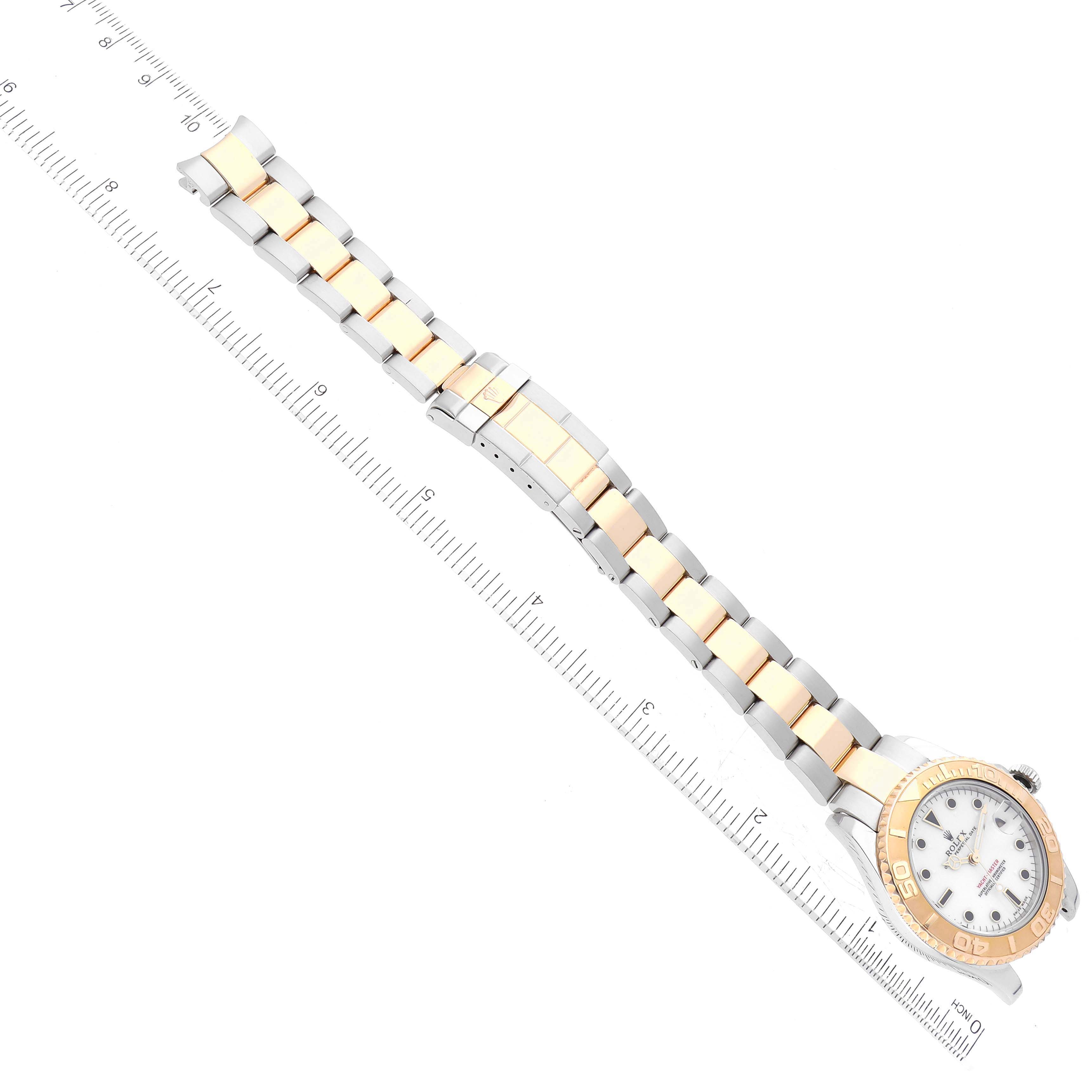 The Rolex Yacht-Master 168623 Men
s Steel and Gold (two tone) White Dial 168623 Men
s Steel and Gold (two tone) White Dial watch is displayed at a top-down angle showcasing the face, bezel, and full bracelet alongside a ruler for scale.