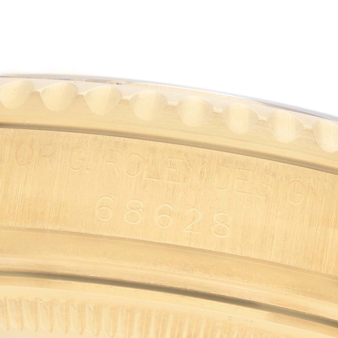 The image shows the edge and engraving details of a Rolex Yacht-Master 68628 Men's Yellow Gold White Dial watch bezel.