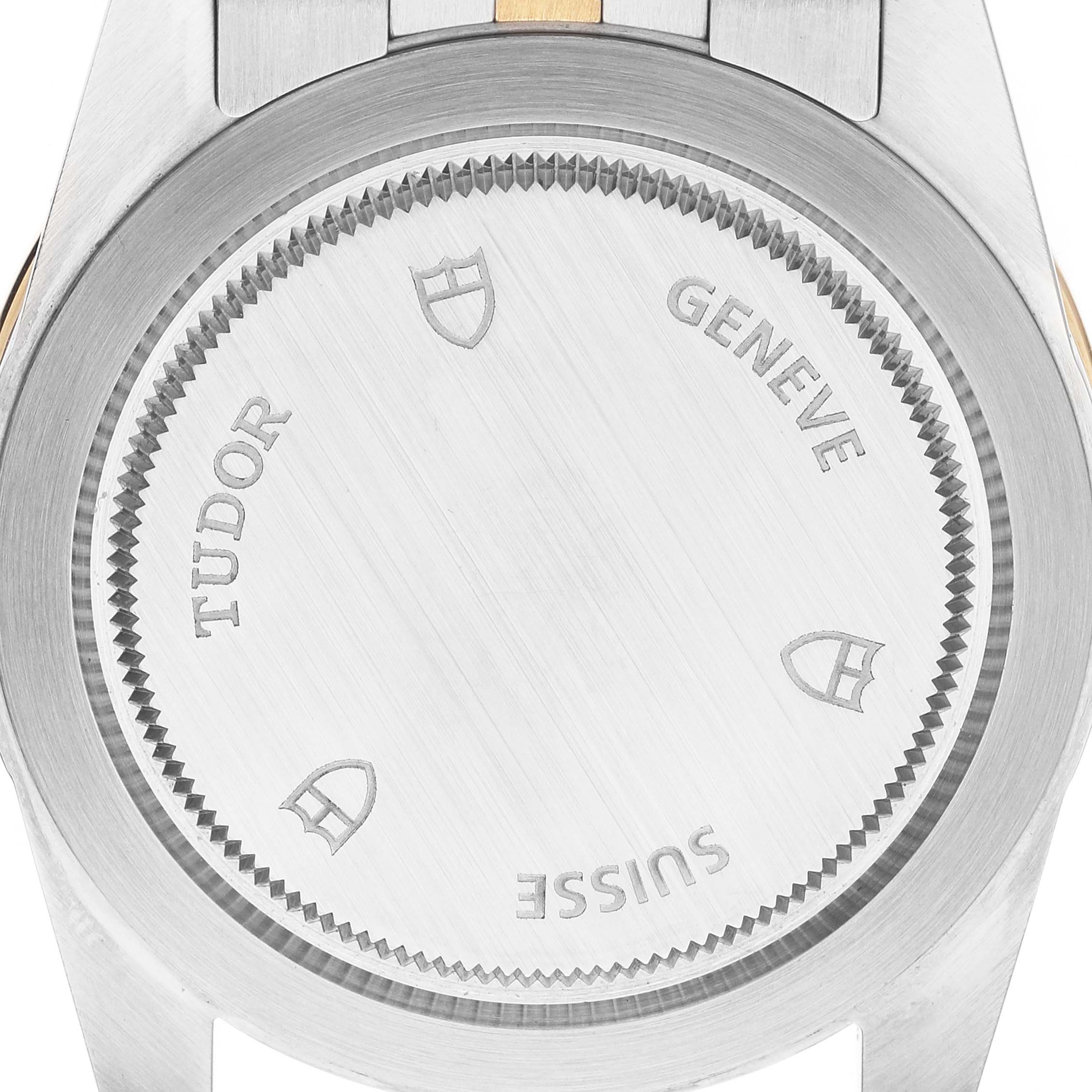 The image shows the case back of a Tudor Glamour 55003-0007 Men's Steel and Gold (two tone) Black Dial watch, featuring branding and a smooth metal finish.