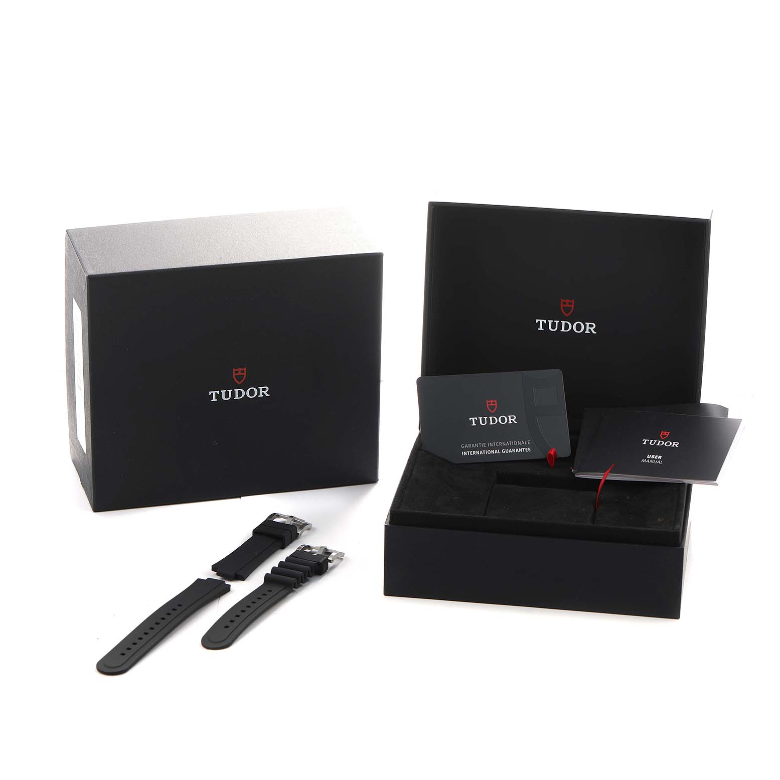 The image shows the Tudor Pelagos 25407N Men's Titanium Black Dial packaging, warranty cards, and extra straps from an overhead angle.