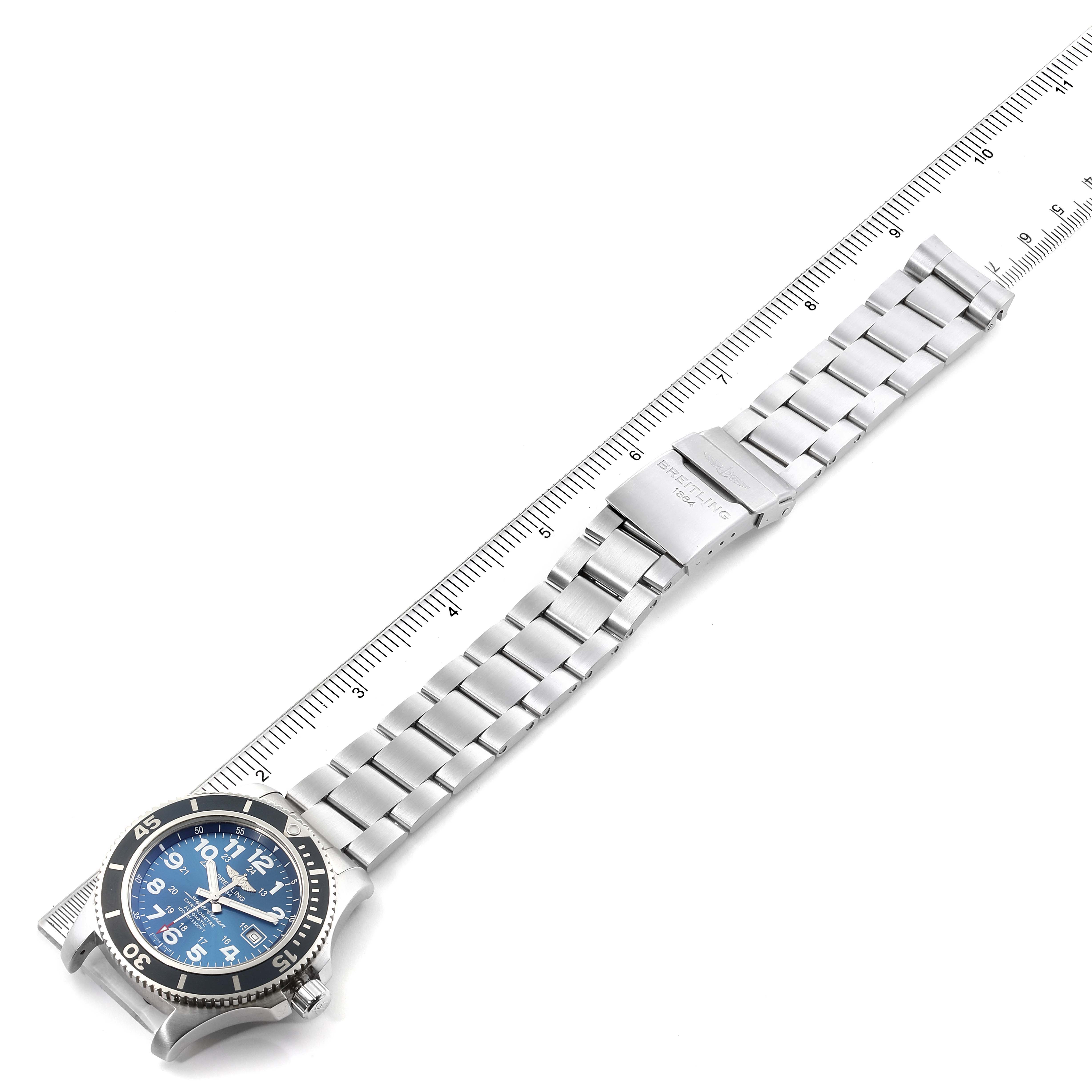 The image shows a Breitling Superocean A17392 Men's Stainless Steel Blue Dial A17392 Men's Stainless Steel Blue Dial watch laid flat with a blue dial, stainless steel bracelet, and ruler.