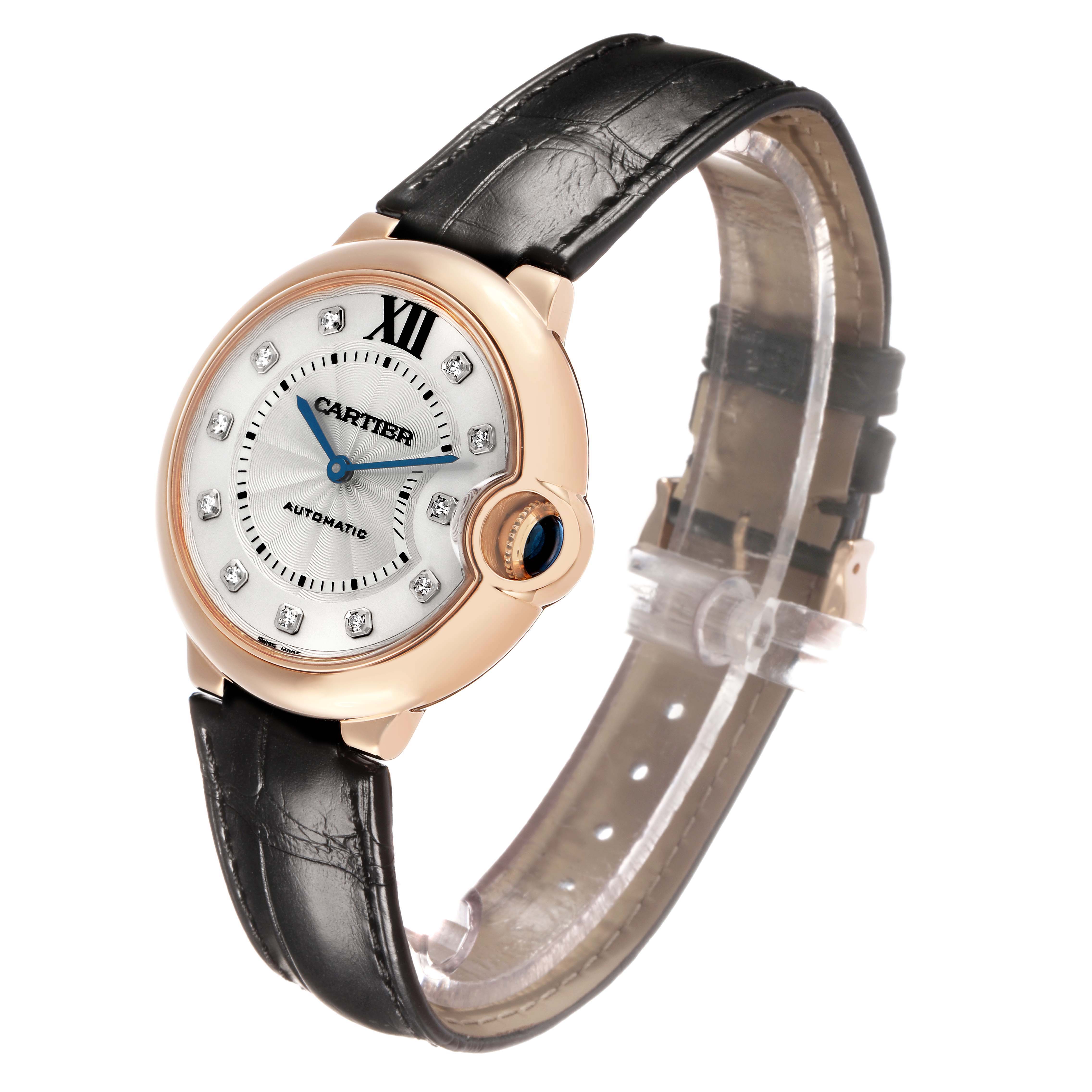 The Cartier Ballon Bleu WE902028 Women's Rose Gold Silver Dial watch is shown from a three-quarter angle, displaying its dial, bezel, and leather strap.