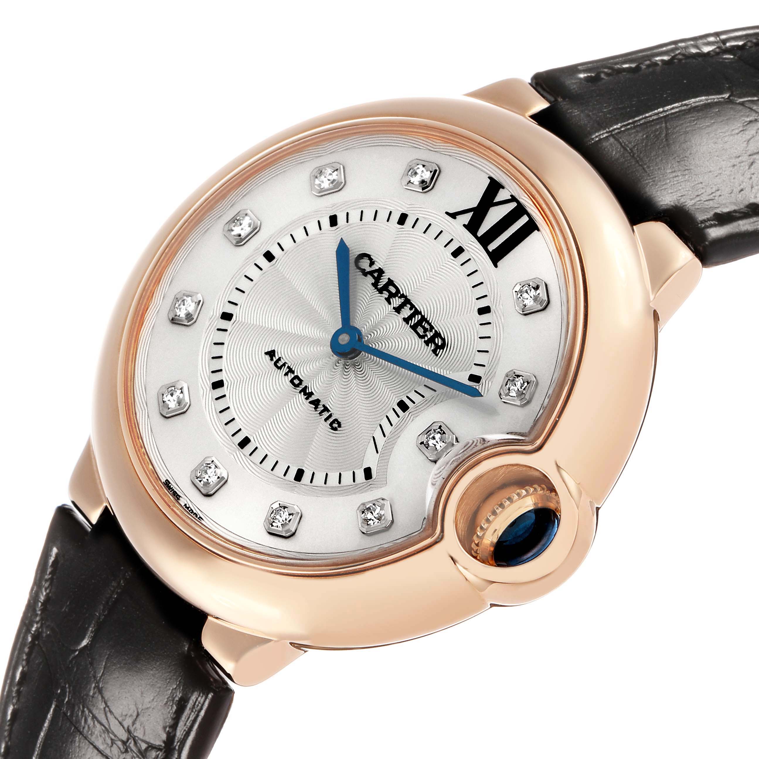 The Cartier Ballon Bleu WE902028 Women's Rose Gold Silver Dial watch is shown at a slight angle highlighting the case, face, crown with blue cabochon, and leather strap.
