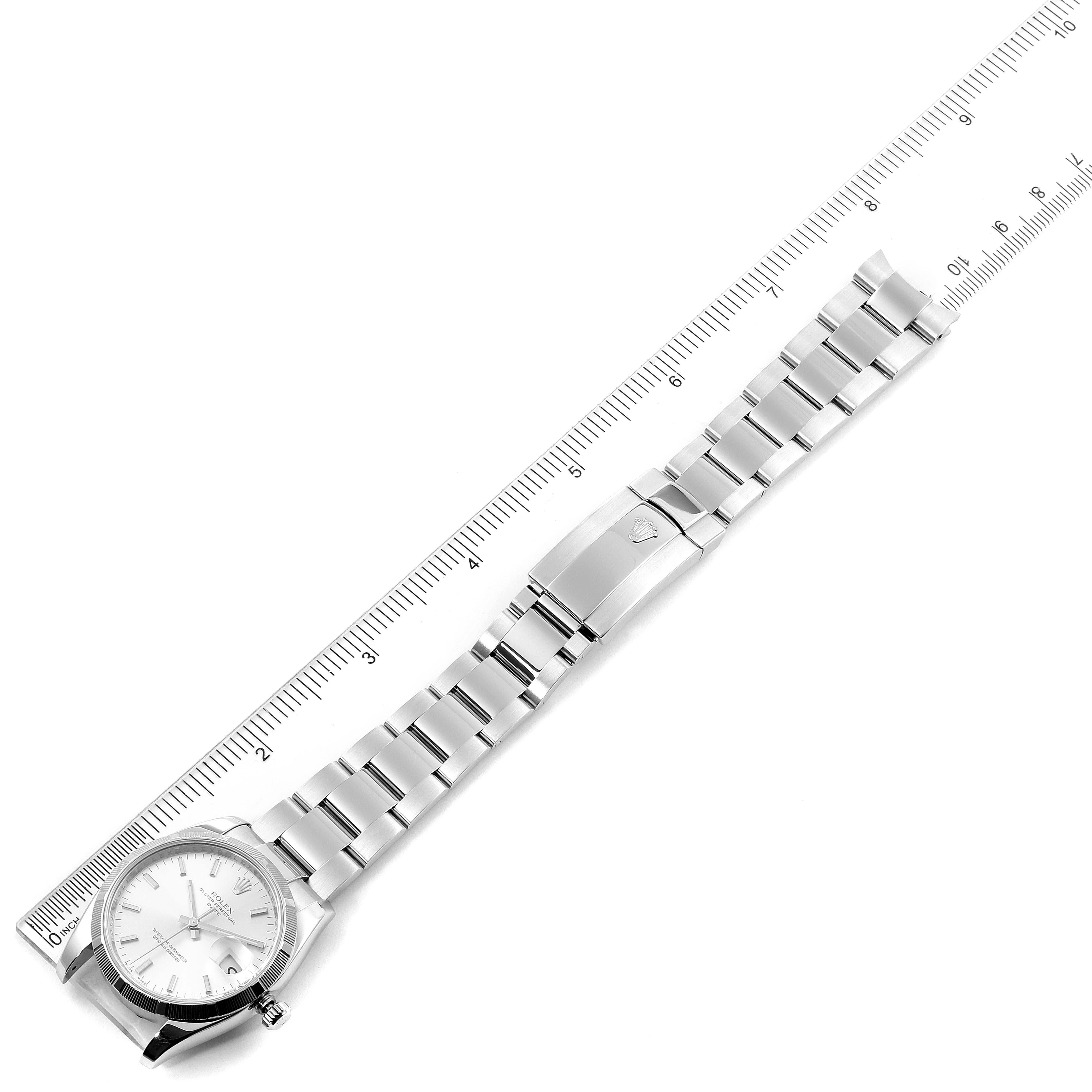 This image shows a Rolex Date 115210 Men's Stainless Steel Silver Dial 115210 Men's Stainless Steel Silver Dial model watch laid flat with a ruler, displaying its side view, face, and metal bracelet.