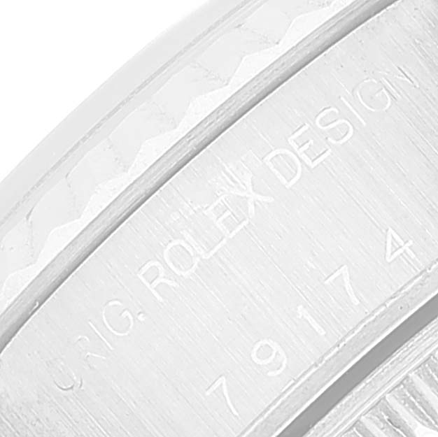 The image shows a close-up of the engraved case edge of a Rolex Datejust 79174 Women's Stainless Steel Pink Dial 79174 Women's Stainless Steel Pink Dial watch.