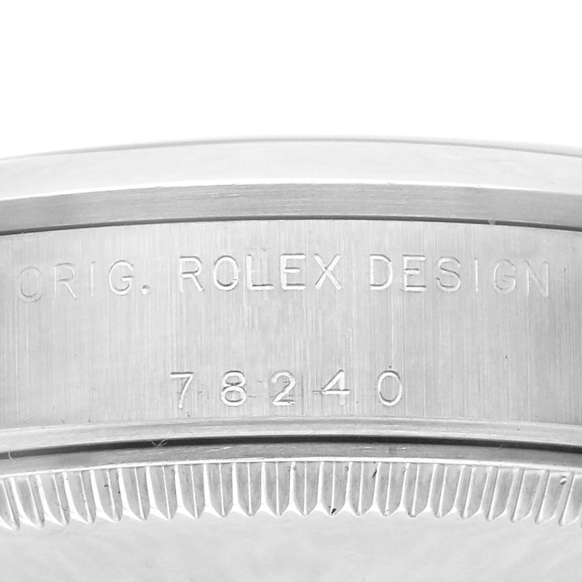 The image shows the side of a Rolex Mid-Size 78240 Women's Stainless Steel Silver Dial 78240 Women's Stainless Steel Silver Dial watch, focusing on the casing with engraved design numbers.