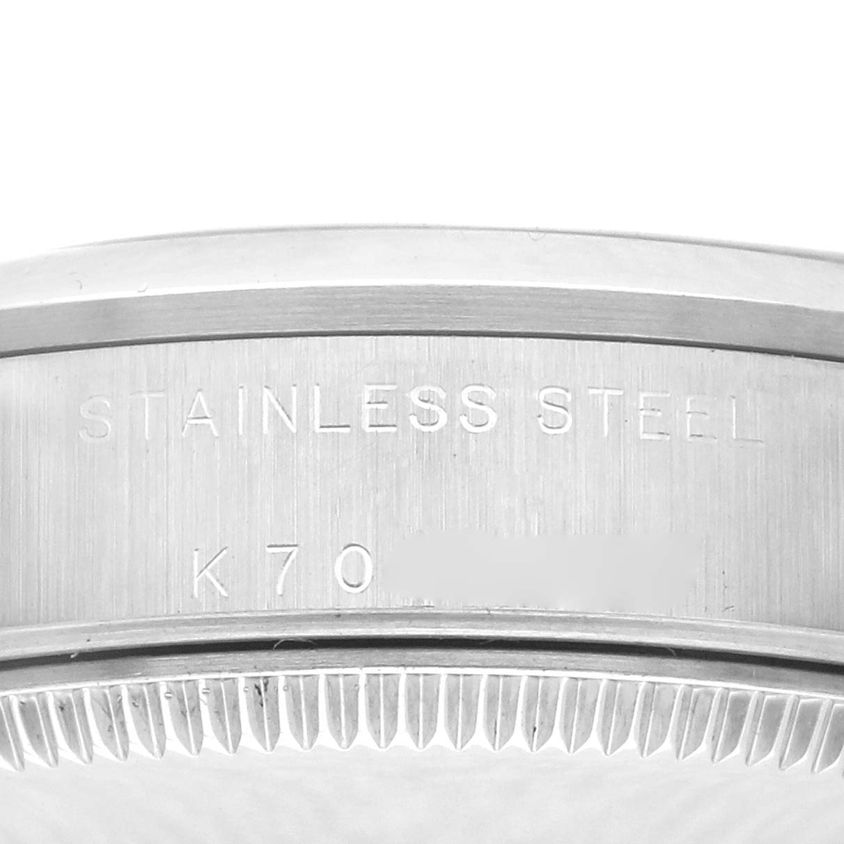 The image shows a close-up of the case side and edge of a mid-size Rolex watch, highlighting the stainless steel and serial number engraving.