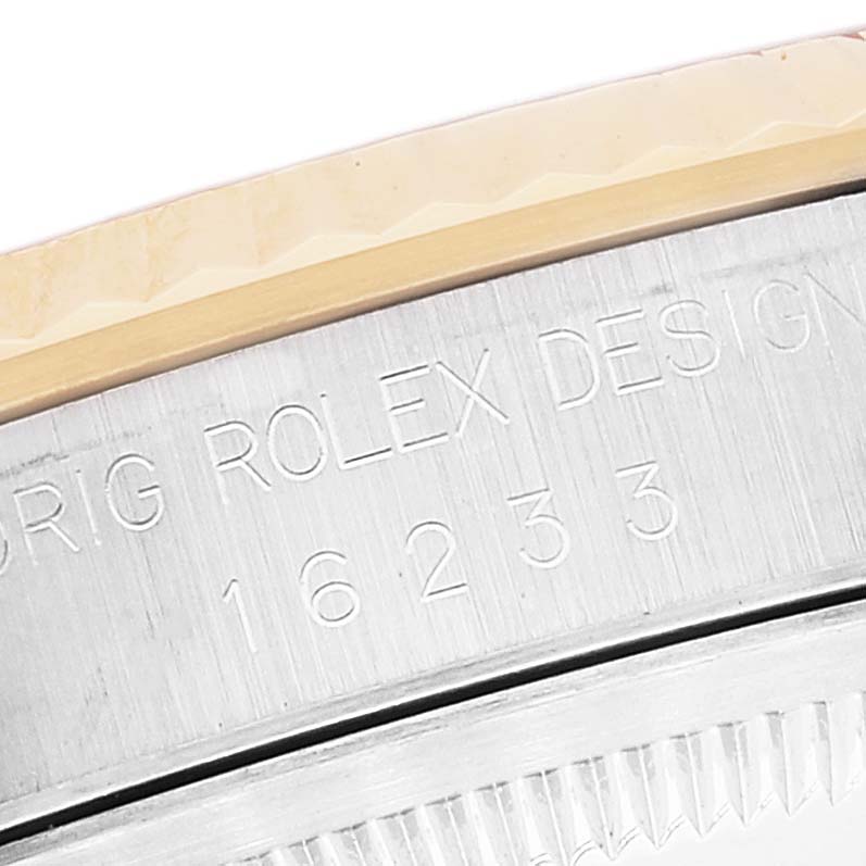 This image shows a close-up of the engraved bezel and casing of a Rolex Datejust 16233 Men's Steel and Gold (two tone) White Dial 16233 Men's Steel and Gold (two tone) White Dial watch.