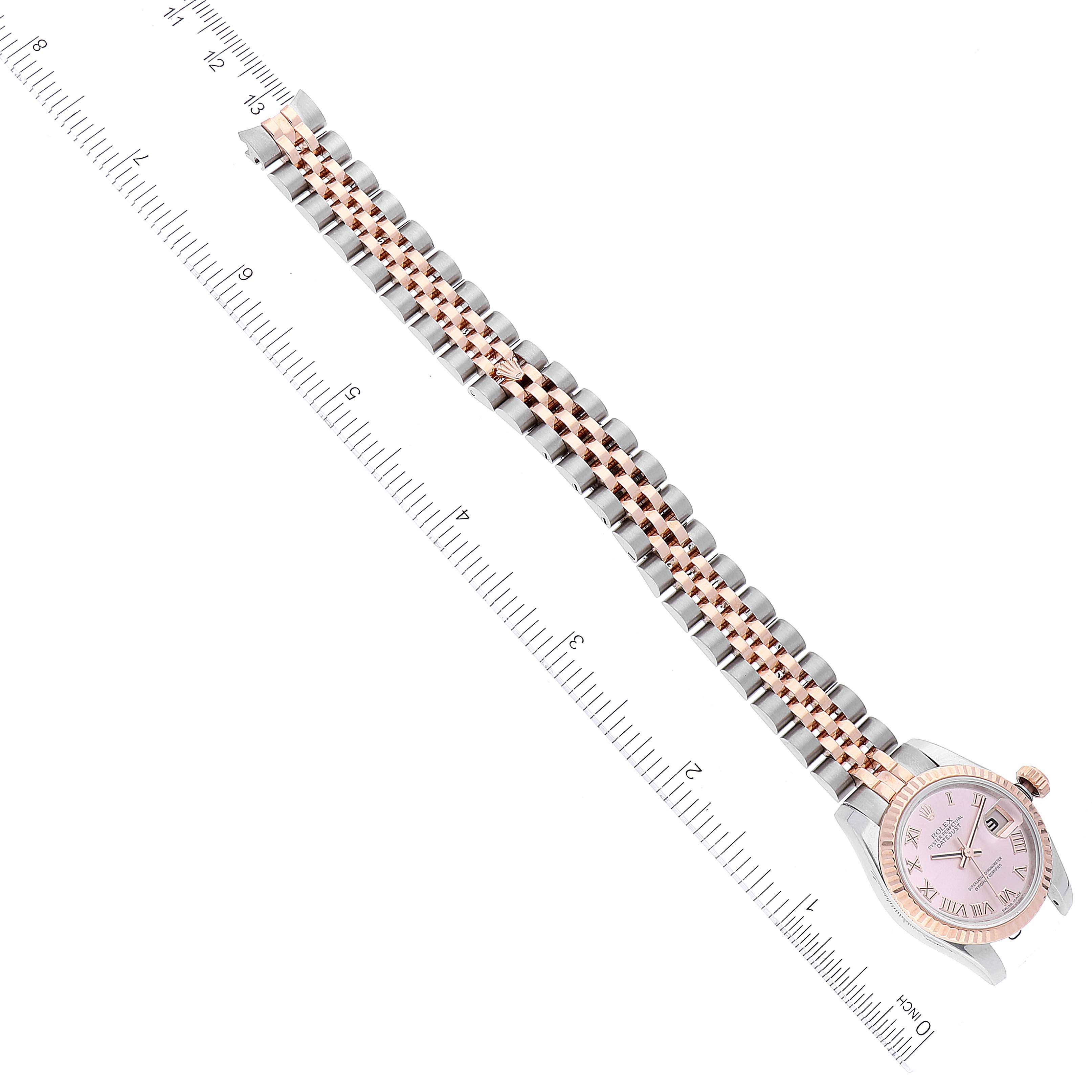 The image shows a Rolex Datejust 179171 Women's Steel and Gold (two tone) Pink Dial 179171 Women's Steel and Gold (two tone) Pink Dial watch positioned diagonally alongside a measuring ruler, showcasing the entire watch and its two-tone bracelet.