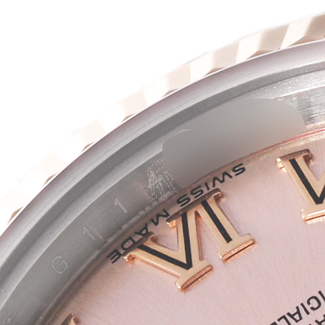This close-up angle of a Rolex Datejust 179171 Women's Steel and Gold (two tone) Pink Dial 179171 Women's Steel and Gold (two tone) Pink Dial watch shows part of the bezel, dial, and Roman numeral VI.