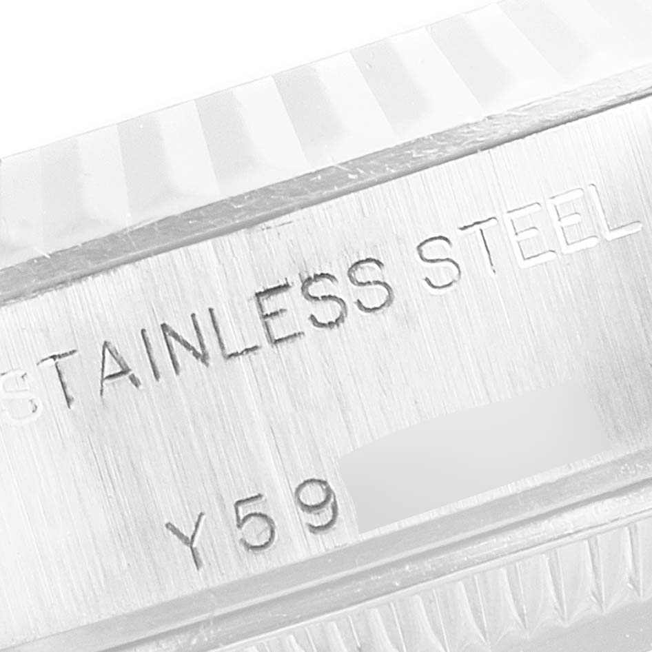 The image shows a close-up of the side of a Rolex Datejust 79174 Women
s Stainless Steel Pink Dial 79174 Women
s Stainless Steel Pink Dial watch, highlighting the "STAINLESS STEEL" engraving and a partial serial number.