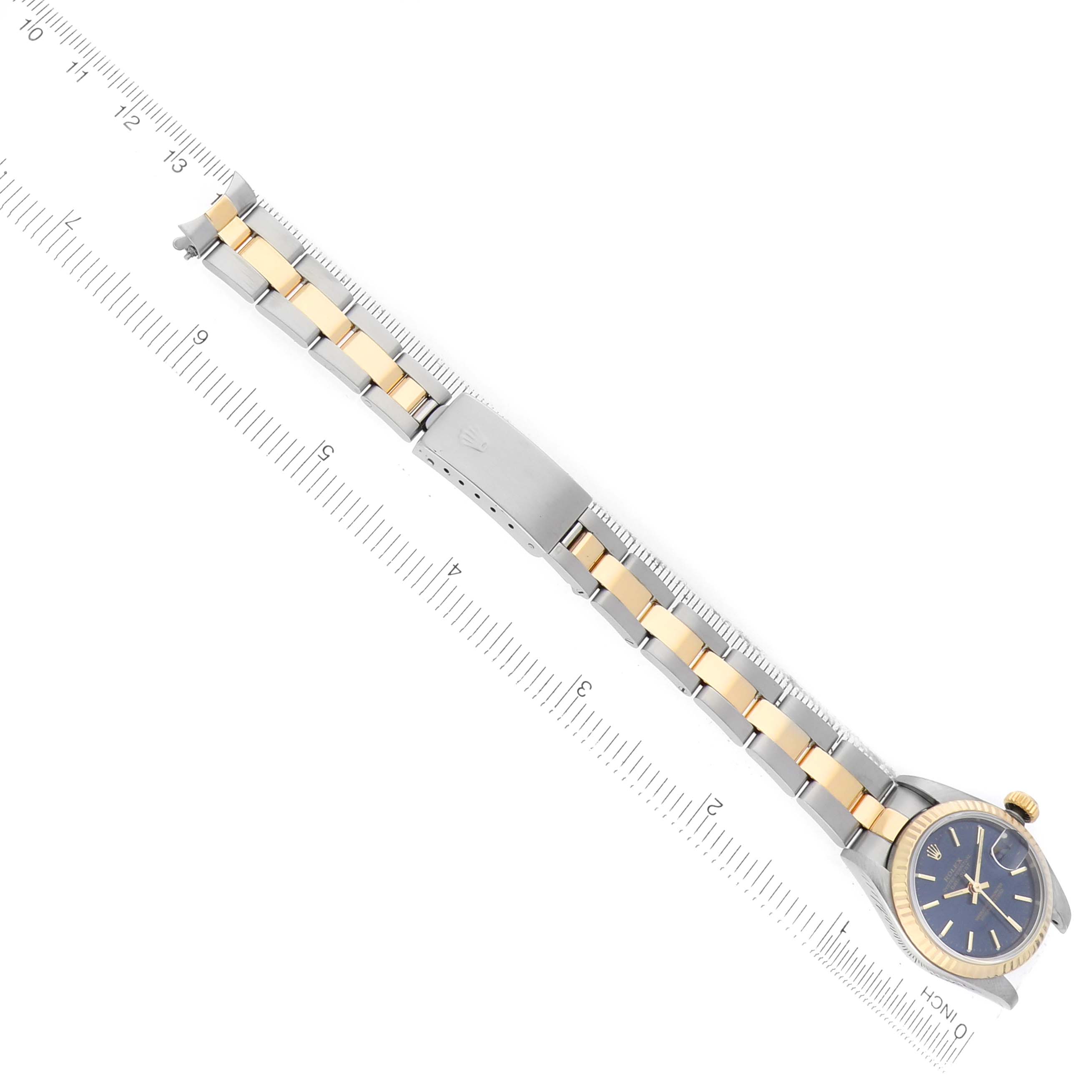 The Rolex Datejust 79173 Women's Steel and Gold (two tone) Blue Dial watch is shown at an overhead angle, displaying the face, bezel, and bracelet with a clasp.