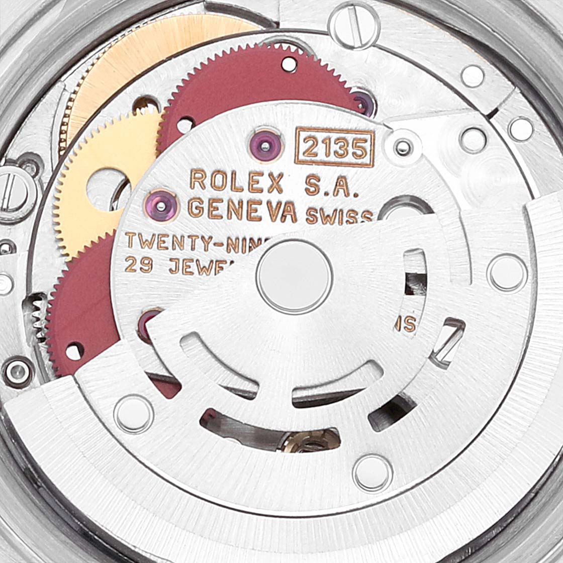 This image shows the intricate internal mechanism of the Rolex Datejust 69173 Women's Steel and Gold (two tone) Beige Dial 69173 Women's Steel and Gold (two tone) Beige Dial watch, highlighting gears and the rotor with inscriptions.
