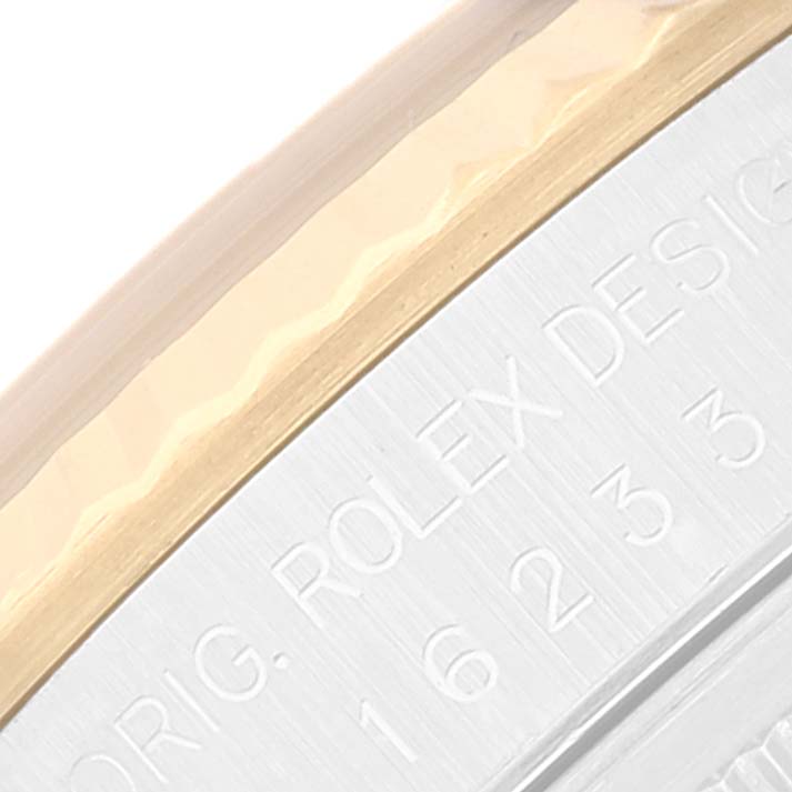 The image shows a close-up of the side of a Rolex Datejust 16233 Men's Steel and Gold (two tone) Beige Dial 16233 Men's Steel and Gold (two tone) Beige Dial model watch, featuring part of the bezel and engraved text.
